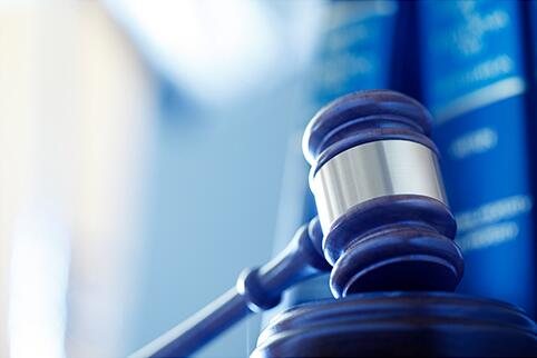 Judge's gavel sitting in front of two hard bound books